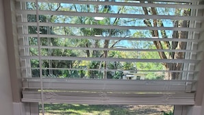 A kitchen with a stainless steel sink, a window with blinds, and a view of a garden. - Quiet Neighborhood and close to all Tampa offers (Tampa)