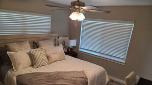 A bedroom with a bed, pillows, a nightstand, a lamp, and a ceiling fan. - Quiet Neighborhood and close to all Tampa offers (Tampa)