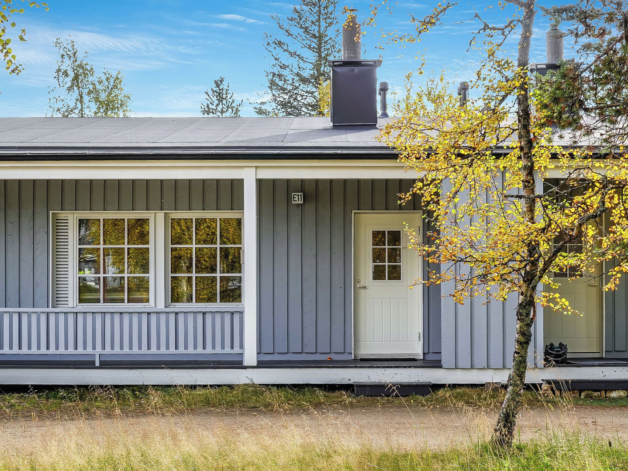 A single-story house with a porch, a chimney, and a door.