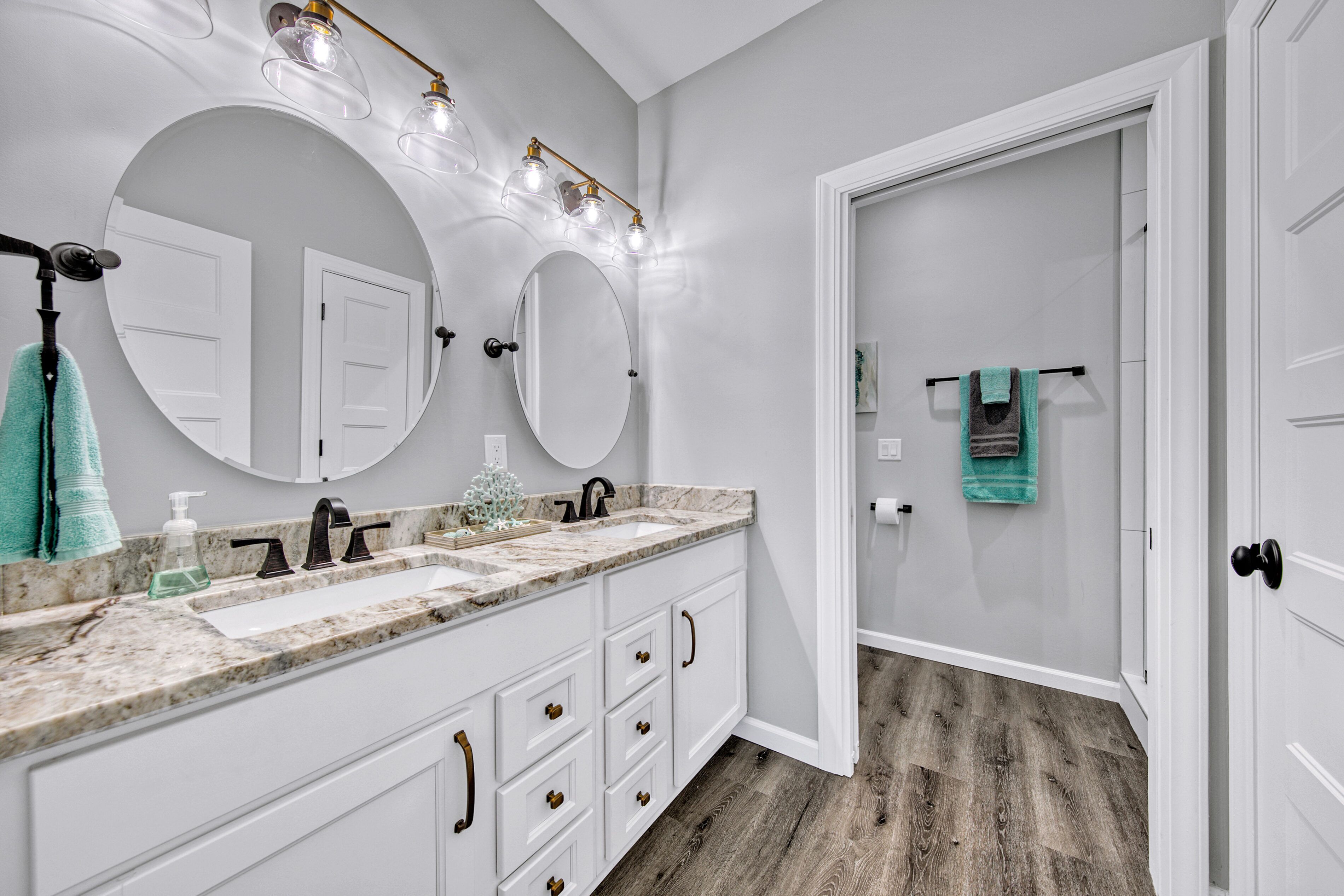 A bathroom with two sinks, a large mirror, and a vanity with drawers.