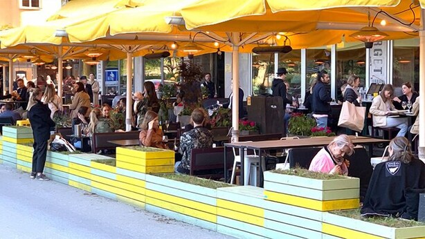 An outdoor café with yellow umbrellas, outdoor seating, and a view of the street. - Beautiful 1-Bed Apartment in Stockholm (Stockholm)