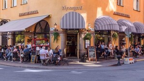 An outdoor seating area of Nyutorget 6 with a bar and restaurant. - Beautiful 1-Bed Apartment in Stockholm (Stockholm)