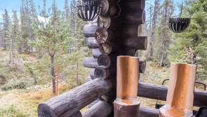 A rustic wooden deck with a log railing, surrounded by a forested landscape. - Vuosselin kuukkeli by Interhome (Kuusamo)