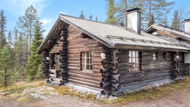 A log cabin with a steeply pitched roof, large windows, and a chimney. - Vuosselin kuukkeli by Interhome (Kuusamo)