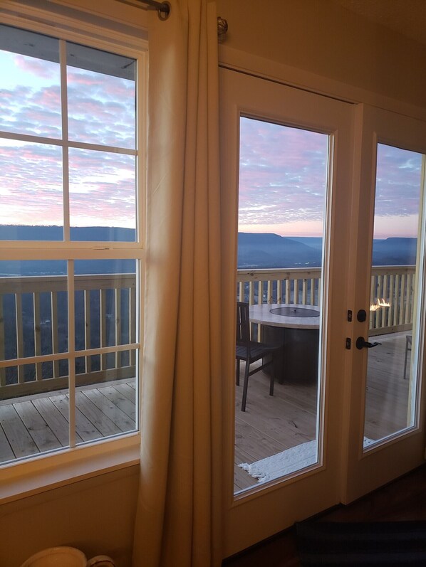Une chambre avec vue sur une terrasse et les montagnes.