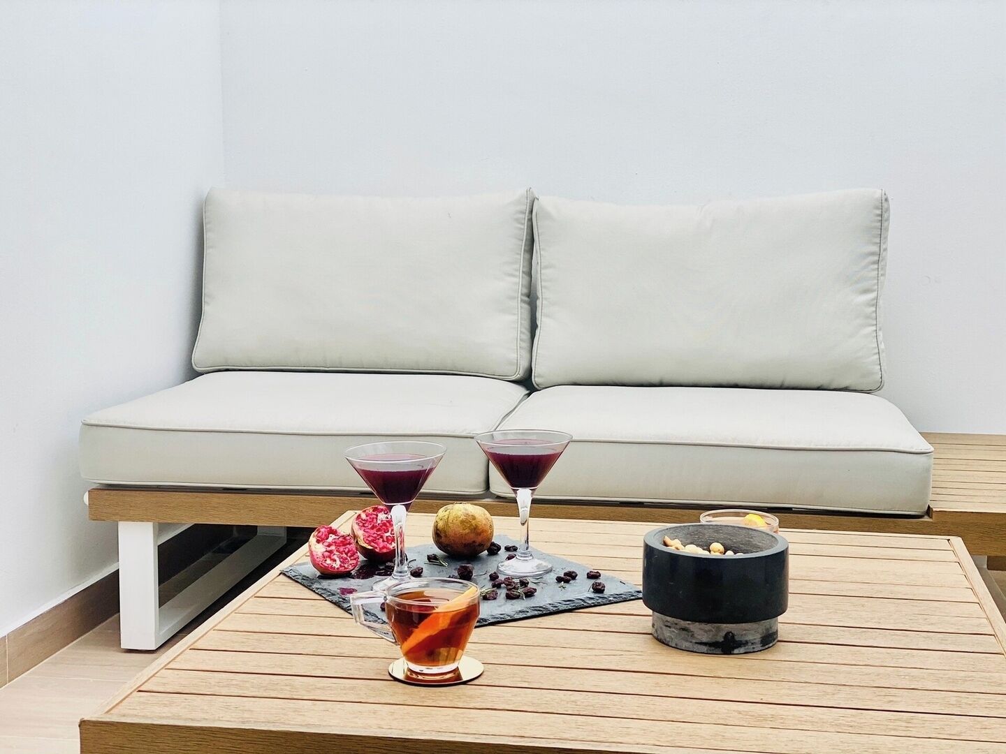 A modern living room with a light-colored sofa, a wooden coffee table, and a small black heater.