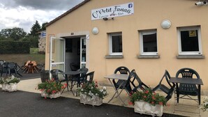 Un petit café appelé « Petit Fanais », doté d’une terrasse et de jardinières.