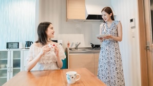 Eine moderne Küche mit weißen Schränken, einem Holztisch und einer Kaffeemaschine.