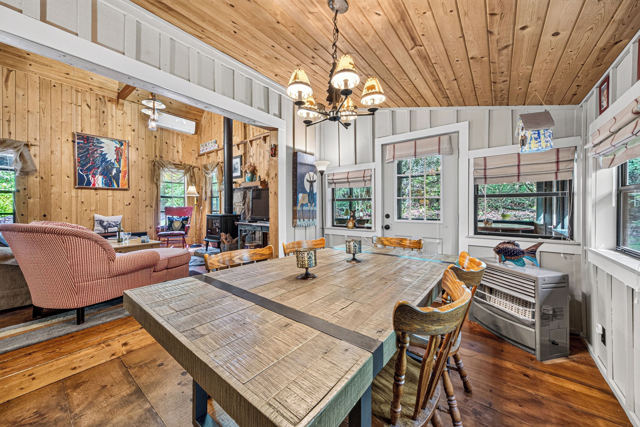 A spacious living room with a large wooden table, comfortable seating, and a fireplace.