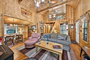 L’intérieur d’un chalet accueillant, avec un coin repas, un canapé et une cheminée.