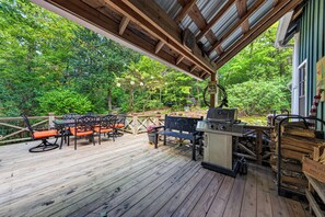 An outdoor deck with a grill and seating area, surrounded by trees. - Perfect Cabin Near Lake Rabun Beach, Beautiful Hikes, Waterfalls, Tallulah Gorge (Lakemont)