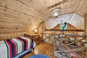 A wooden cabin with a bunk bed, a small table with a lamp, and a staircase leading to an upper level. - Perfect Cabin Near Lake Rabun Beach, Beautiful Hikes, Waterfalls, Tallulah Gorge (Lakemont)