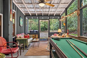 Une pièce confortable avec une table de billard, un canapé et une table à manger.