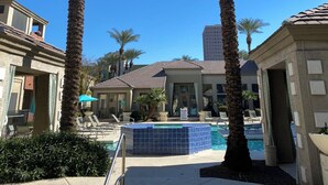 A pool area with palm trees, a clear blue sky, and a building in the background. - 2 Bd/2Ba in Central Phx with a private patio, 2 pools, 2 hot tubs gated complex! (Phoenix)