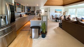 Een moderne keuken met roestvrijstalen apparatuur, een centraal eiland en een eetgedeelte met uitzicht.