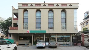 Um edifício com fachada plana, grandes janelas em arco e toldo verde.