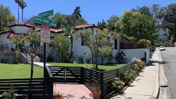 A street view with a sign for Glenridge Ave NW, a sidewalk with a black fence, and a building with a tiled roof.