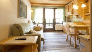 Ein gemütliches Wohnzimmer mit einer Couch, einem Couchtisch und einem Essbereich mit Holzkörpern.