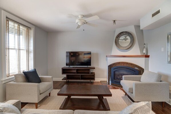 A living room with a TV, fireplace, and two sofas.