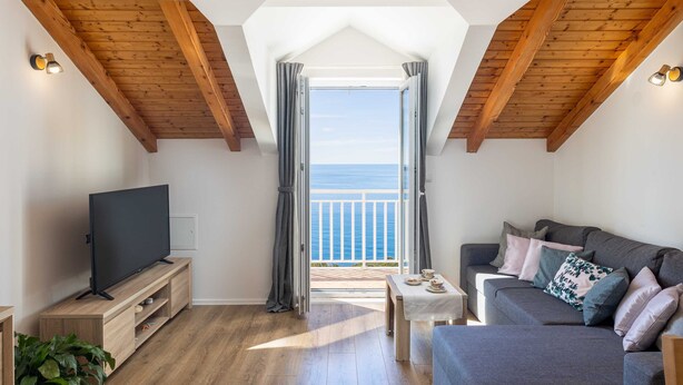 A cozy living room with a TV, a sofa, and a balcony with a view of the sea. - Apartment M&K (Mlini)