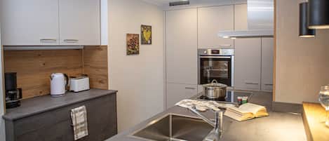 Een koelkast, een oven, een vaatwasser, een kinderstoel