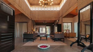 A spacious lobby with a high ceiling, a central chandelier, and a seating area with sofas and a coffee table. - Brij Pola, Jawai - Luxury Jungle Camp with Private Pools (Bali)