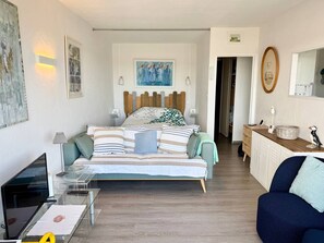 A bedroom with a bed, bedside tables, a desk, a chair, and a dresser. - Apartment for 2, 50m from Beaches, WIFI and Parking (Trégastel)