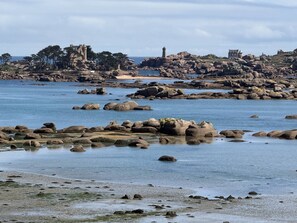 A coastal landscape with rocky shores, a lighthouse, and historical buildings. - Apartment for 2, 50m from Beaches, WIFI and Parking (Trégastel)