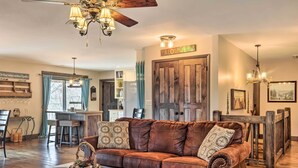 A cozy living room with a brown leather sofa, wooden coffee table, and a ceiling fan. - 'Joshua’s Lodge' w/ Hot Tub + Mountain Views! (Franklin)