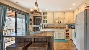 A kitchen with wooden countertops, a built-in island, white cabinets, and a large window with curtains. - 'Joshua’s Lodge' w/ Hot Tub + Mountain Views! (Franklin)