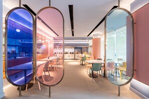 A modern interior with round mirrors, seating areas, and a kitchen visible through glass partitions. - Hanting Hotel (Shanghai)