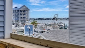 Un port de plaisance avec des bateaux amarrés, un bâtiment avec une enseigne et une vue sur l’eau.