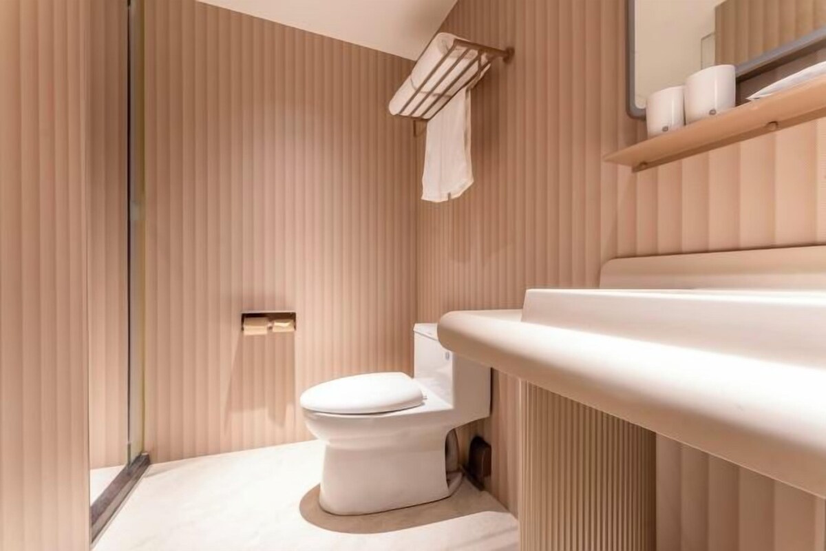 A modern bathroom with a toilet, a sink, and a towel rack.