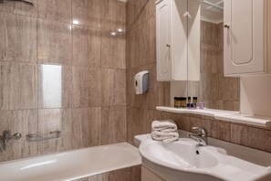 A modern bathroom with a bathtub, a sink, and a hand dryer. - Caldera Bay (Platanias)