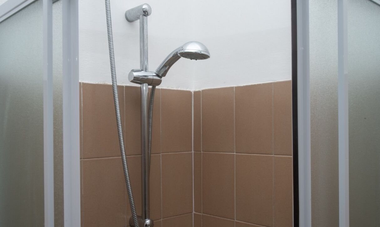 A shower with a handheld showerhead and a flexible hose.