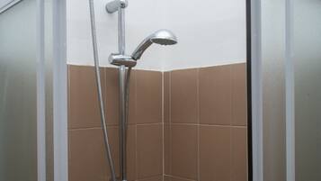 A shower with a handheld showerhead and a flexible hose.