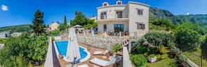 A two-story stone house with a swimming pool, outdoor seating, and a mountainous backdrop. - Mediterranean Villa with a private pool, Dubrovnik (Rožat)