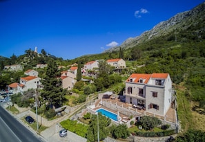 Una zona residencial en una ladera con casas, piscina y carretera.