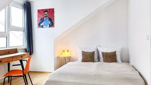 Une chambre à coucher avec un lit, un bureau et une chaise.