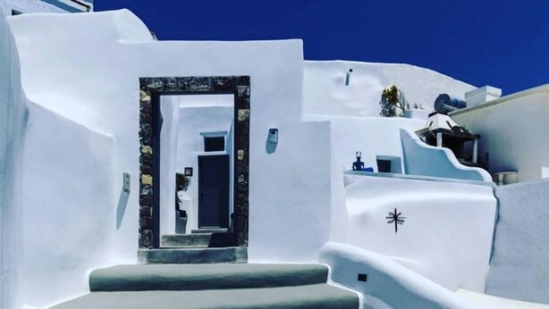 Un edificio blanco con una escalera que lleva a una puerta.