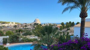 A pool with a view of a coastal town, palm trees, and purple flowers. - VILLA MARIA - Villa with sea views and private pool (Calpe)