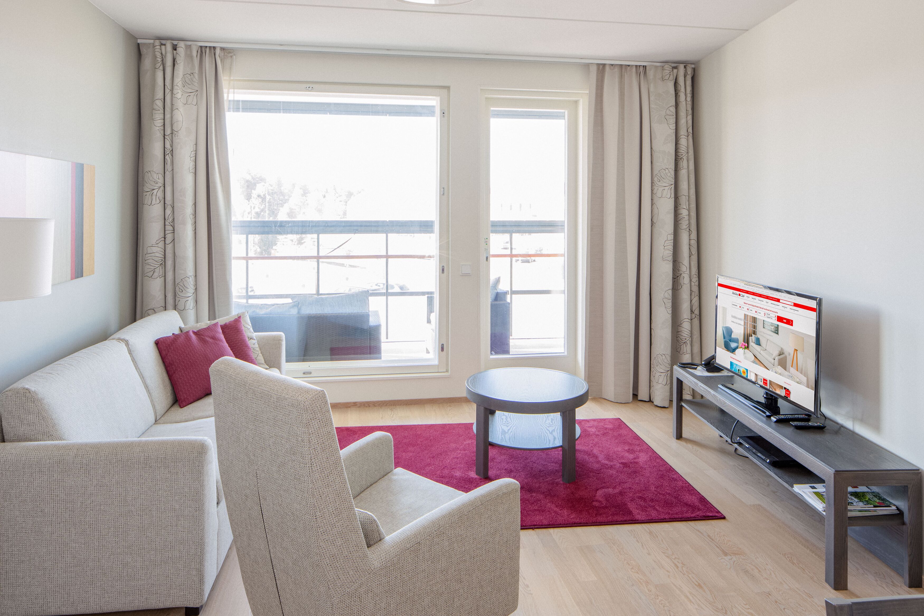 A modern living room with a sofa, armchair, and a small table.