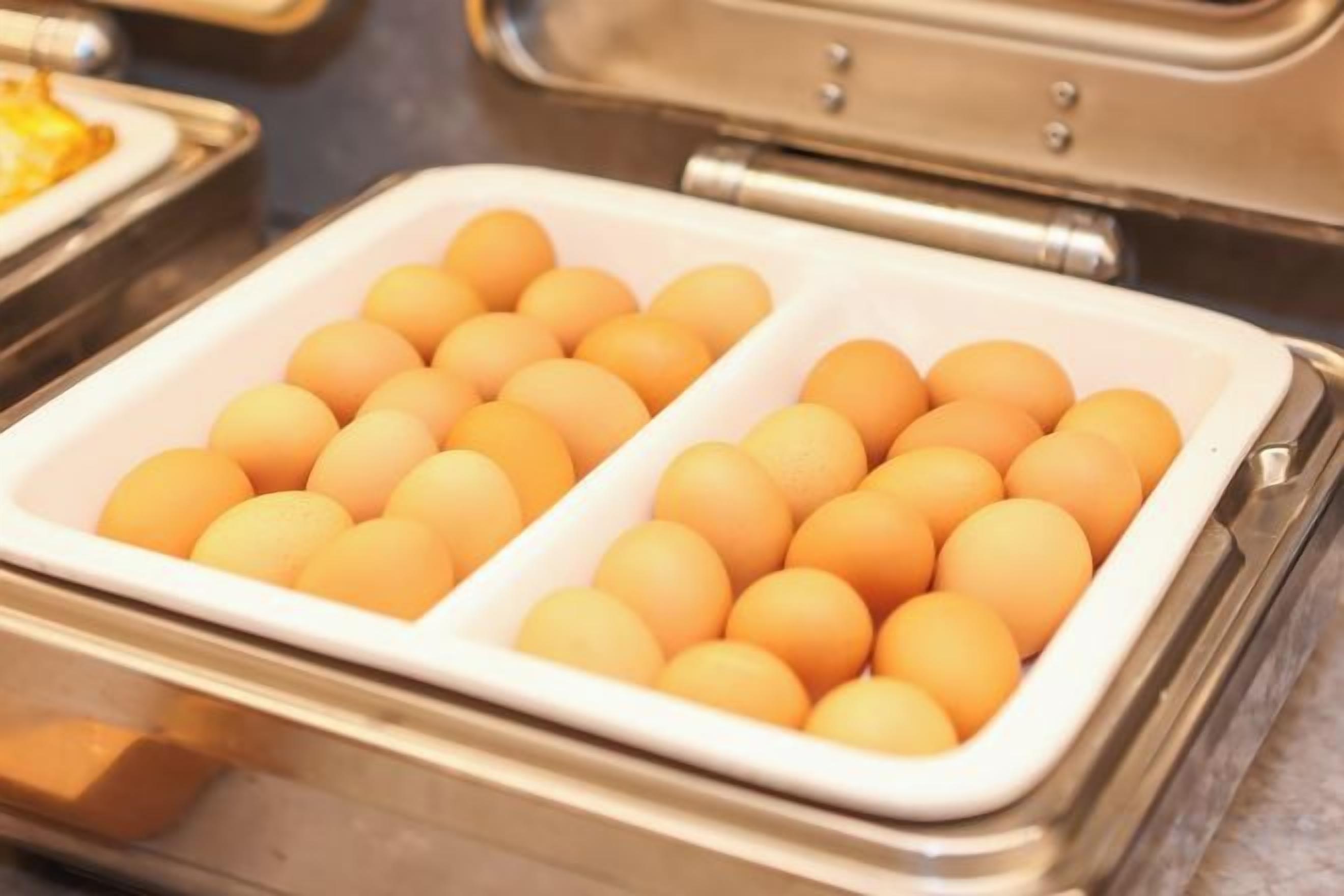 A buffet with a section containing round, orange-colored items, likely eggs, arranged in a tray.