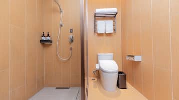 A bathroom with a shower, toilet, and a towel rack.