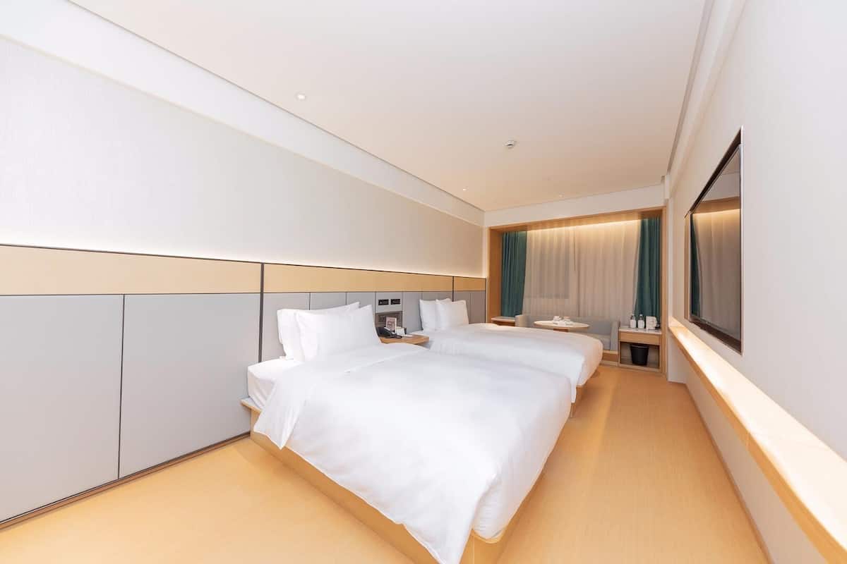 Et moderne hotelværelse med en stor seng, et skrivebord og et fjernsyn.