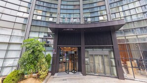 A modern hotel with a curved facade, large glass windows, and a prominent entrance. - Ji Hotel (Hangzhou)