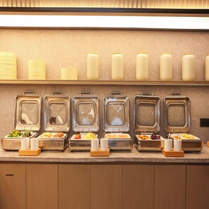 A buffet setup with multiple food dispensers and containers. - Ji Hotel (Hangzhou)