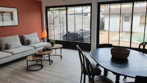 Een moderne woonkamer met een bank, salontafel en eettafel.