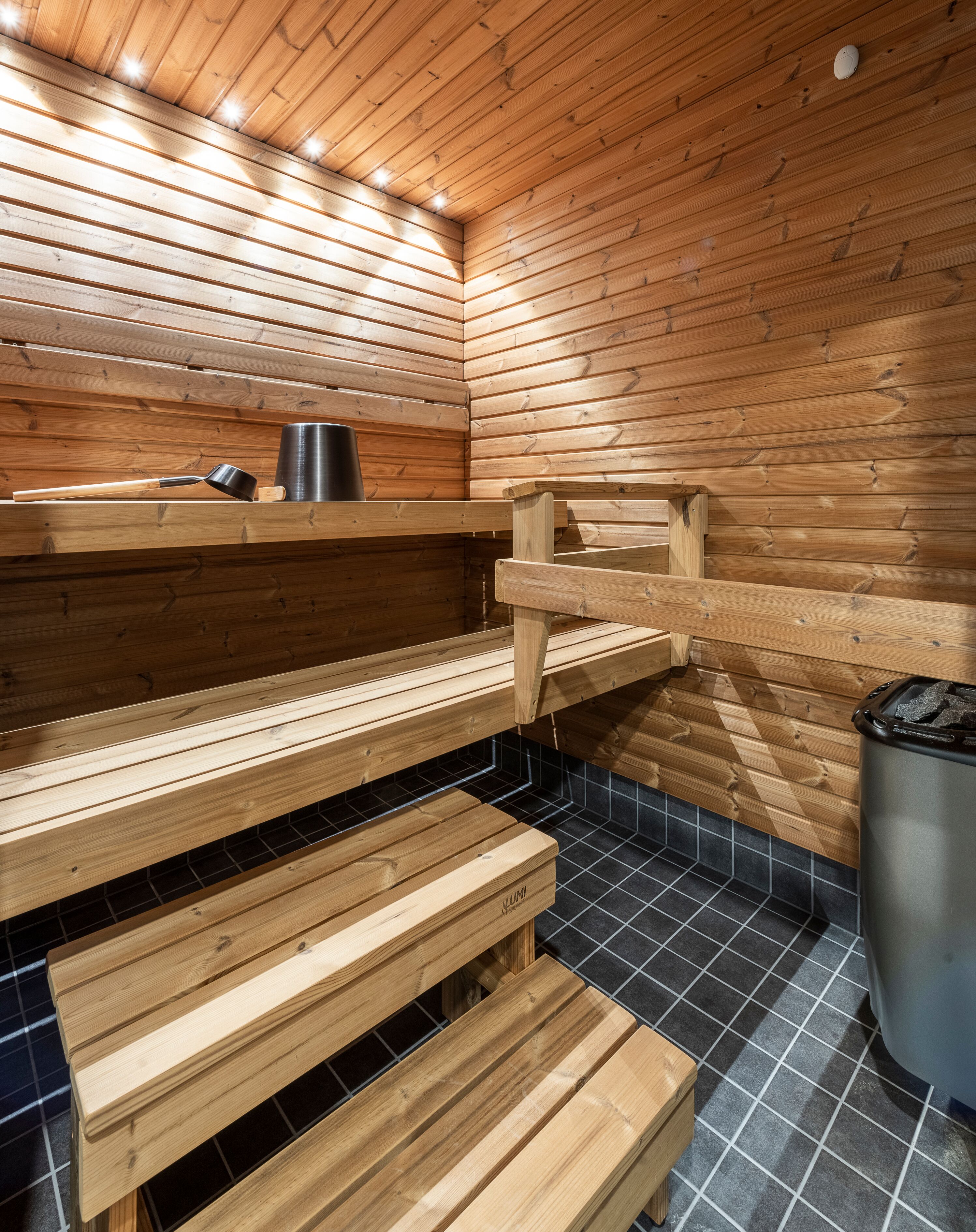A sauna with wooden benches and a tiled floor.