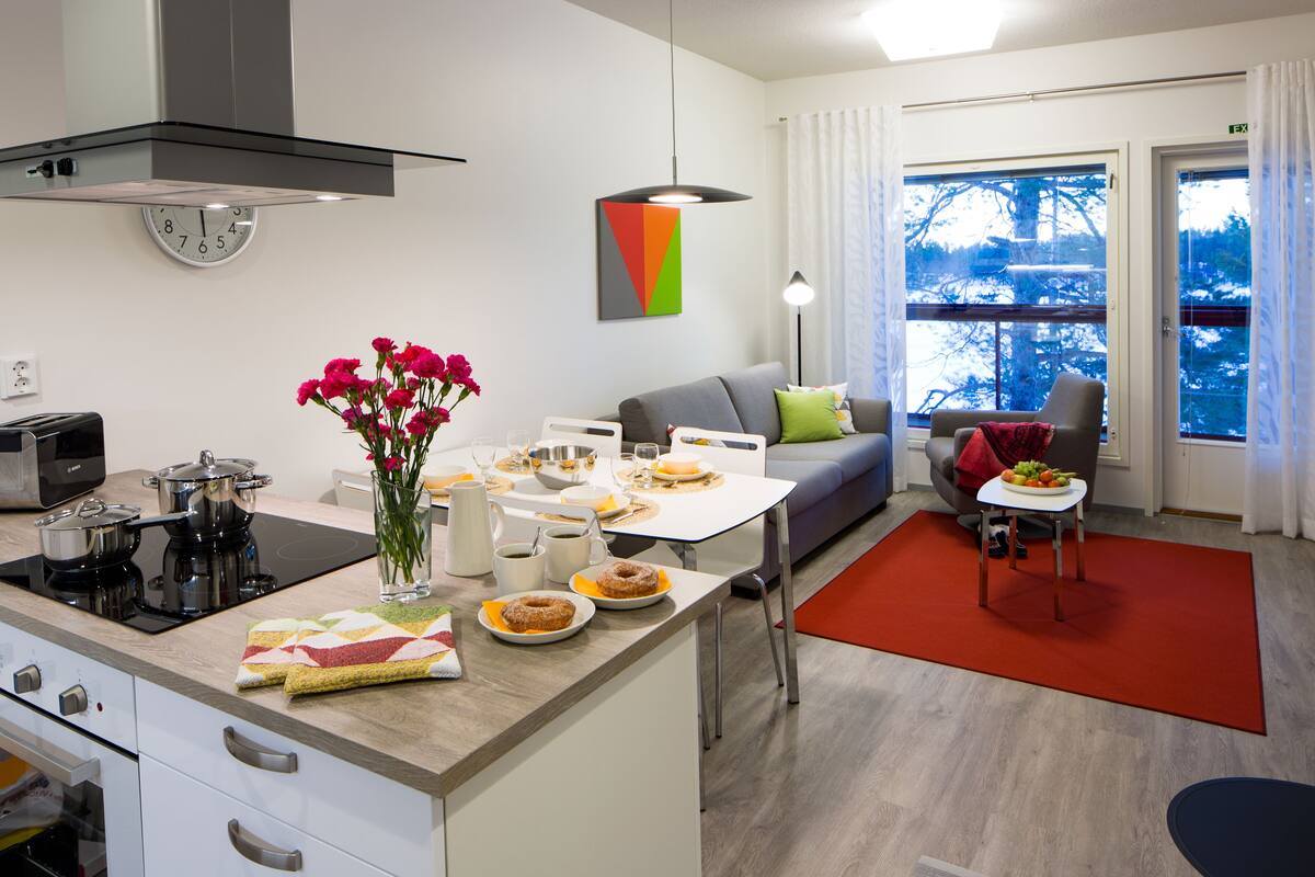 Una cocina moderna con comedor, sofá y vistas al exterior.
